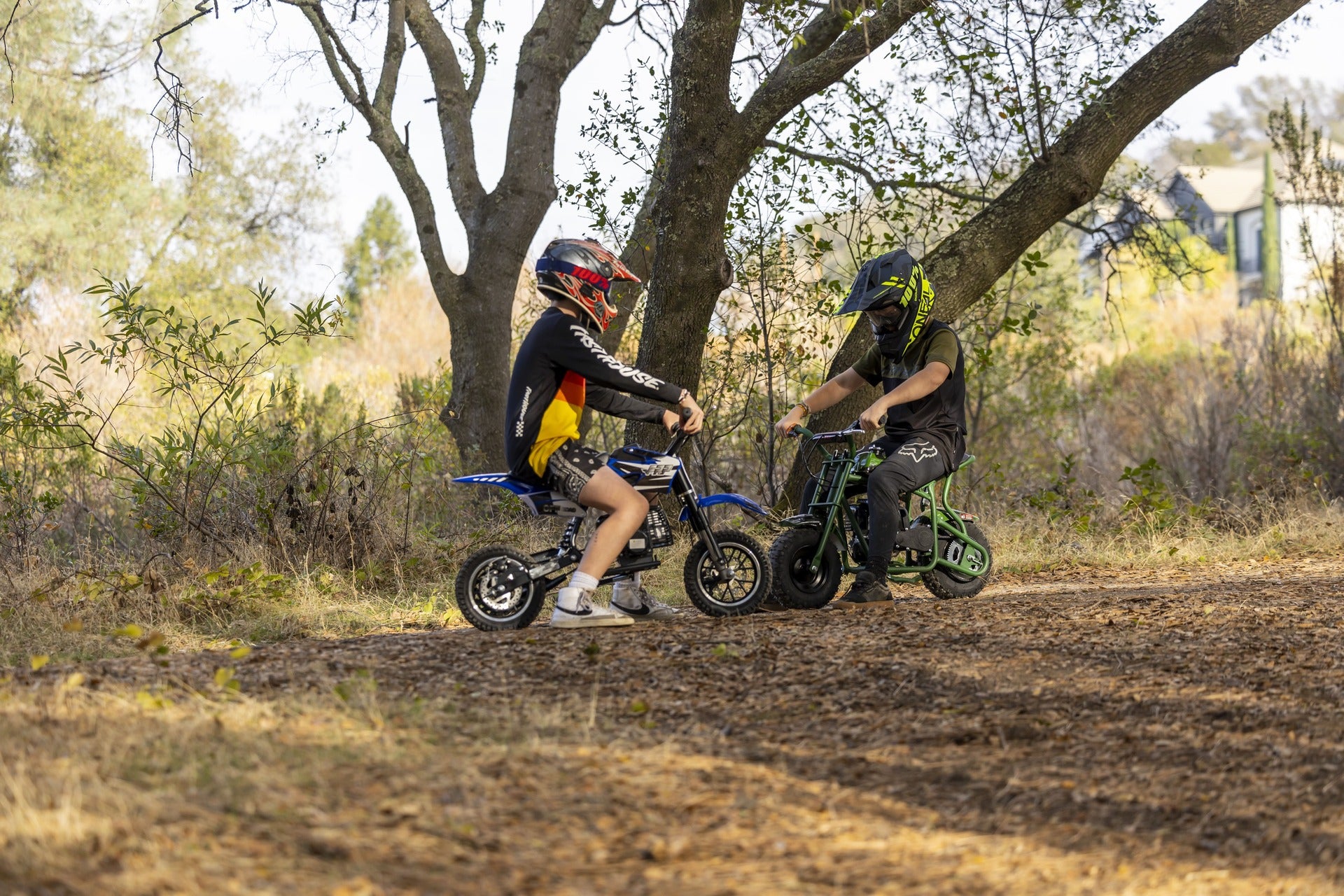 Two kids are riding FRP mini dirt bikes.