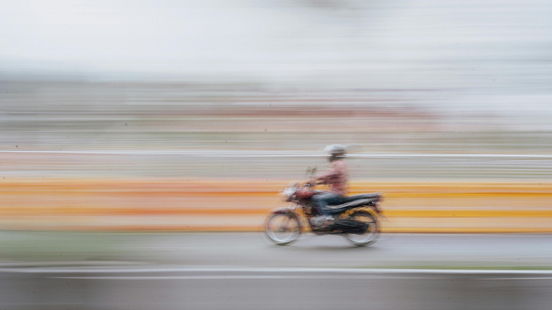 A man is riding a mini bike at high speed.